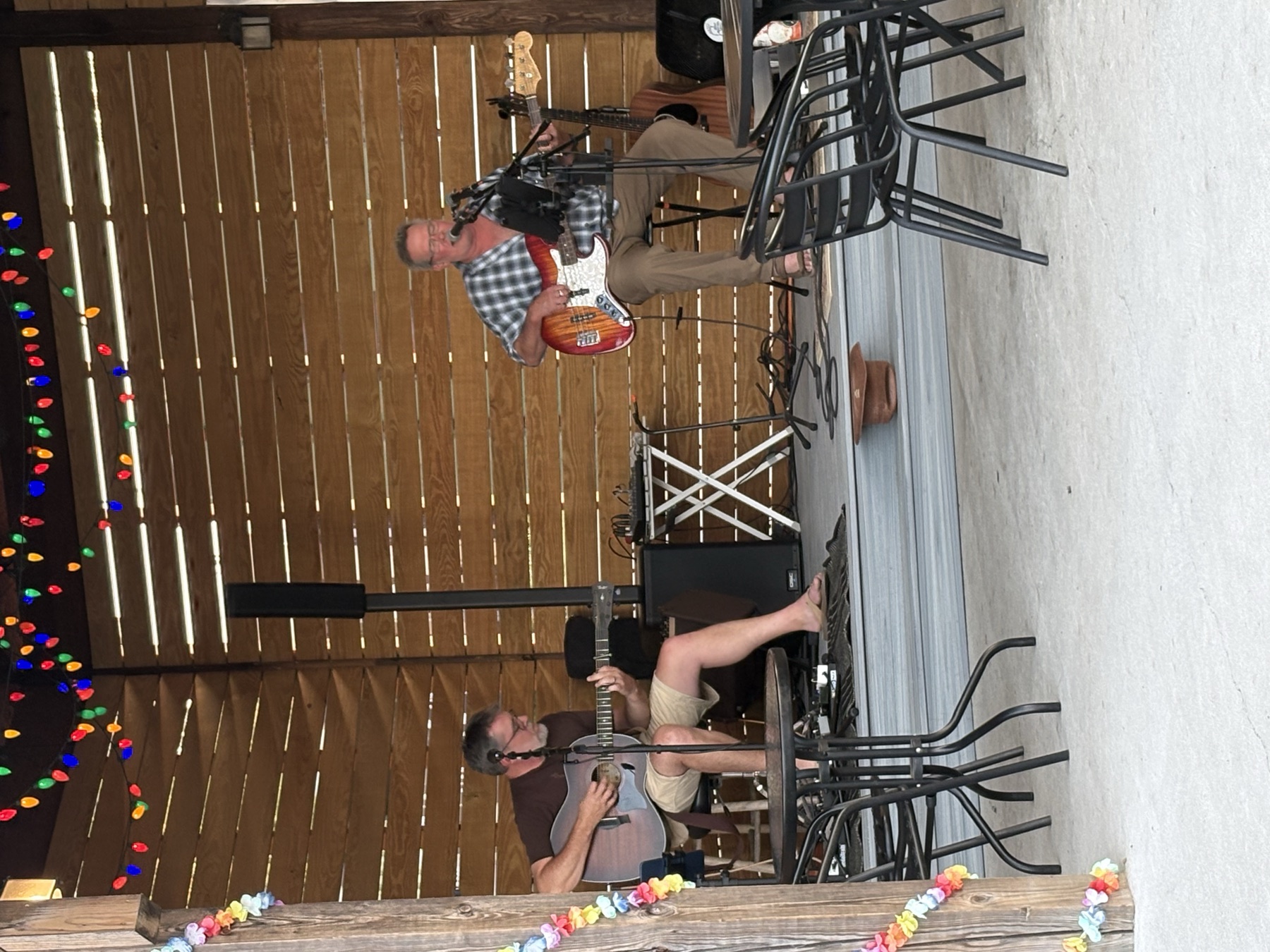 Brent and William performing under string lights at an outdoor venue